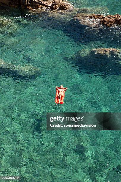 aerial view of young woman floating on pool mattress - airbed stock pictures, royalty-free photos & images