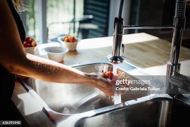 woman's hands washing cherries - woman showering stock-fotos und bilder