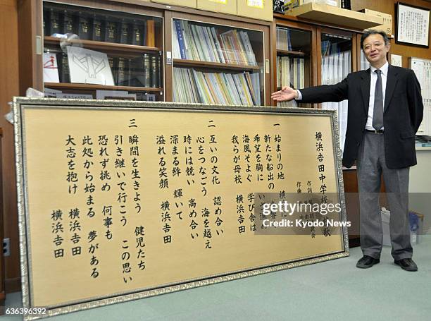 Japan - Susumu Degawa, principal of Yokohama Yoshida Junior High School, stands by a plate incorporating the lyrics of the Yokohama municipal...