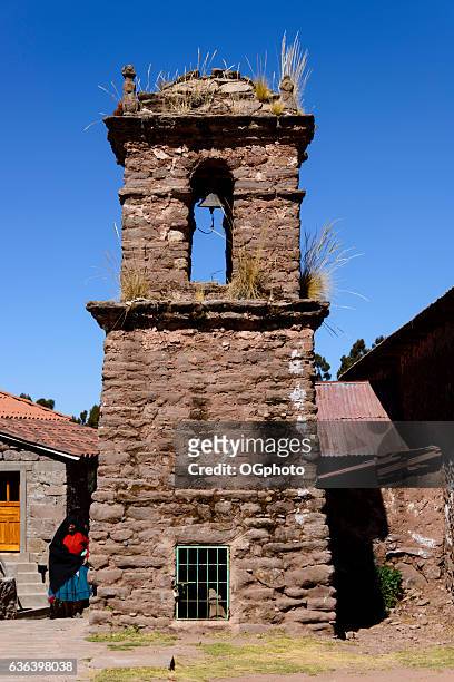 mujer peruana de pie junto a la antigua torre de campanario de piedra - ogphoto fotografías e imágenes de stock