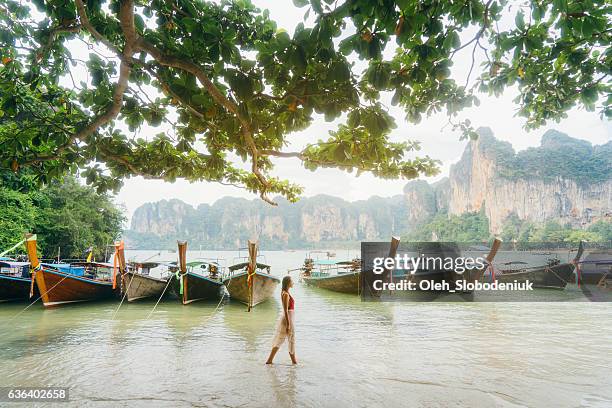 woman near the boats on beach in thailand - railay strand stock pictures, royalty-free photos & images