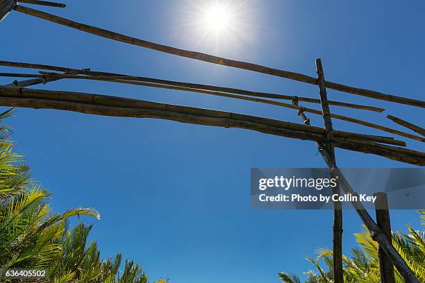 a very shaky bamboo bridge against the sun and a blue sky. - shaky stock pictures, royalty-free photos & images