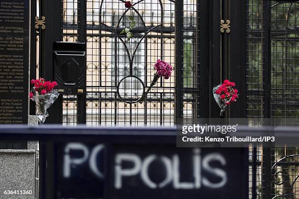 Civilians lay flowers on the gates at the entrance of the Russian Consulate while police and soldiers make their rounds on December 20, 2016 in...
