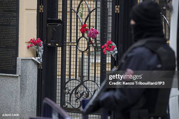 Civilians lay flowers on the gates at the entrance of the Russian Consulate while police and soldiers make their rounds on December 20, 2016 in...