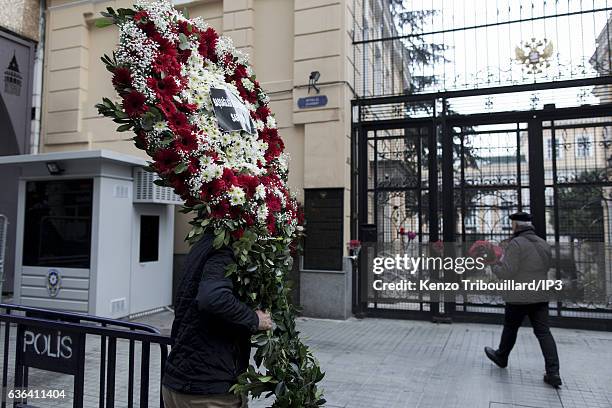 Civilians lay flowers on the gates at the entrance of the Russian Consulate while police and soldiers make their rounds on December 20, 2016 in...