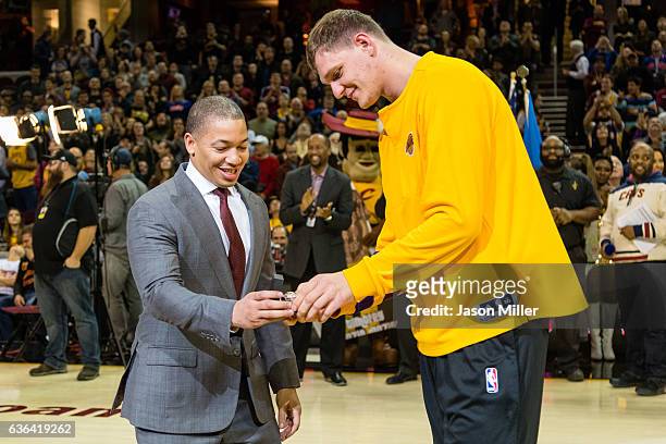 Tyronn Lue of the Cleveland Cavaliers presents Timofey Mozgov of the Los Angeles Lakers with his championship ring prior to the game at Quicken Loans...