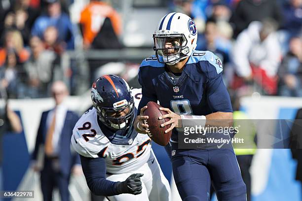 Marcus Mariota of the Tennessee Titans scrambles out of the grasp of Sylvester Williams of the Denver Broncos at Nissan Stadium on December 11, 2016...