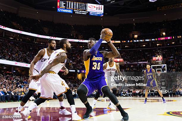 Tristan Thompson and Kyrie Irving of the Cleveland Cavaliers guard Julius Randle of the Los Angeles Lakers during the first half at Quicken Loans...