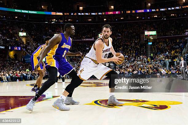 Luol Deng of the Los Angeles Lakers puts pressure on Kevin Love of the Cleveland Cavaliers during the second half at Quicken Loans Arena on December...