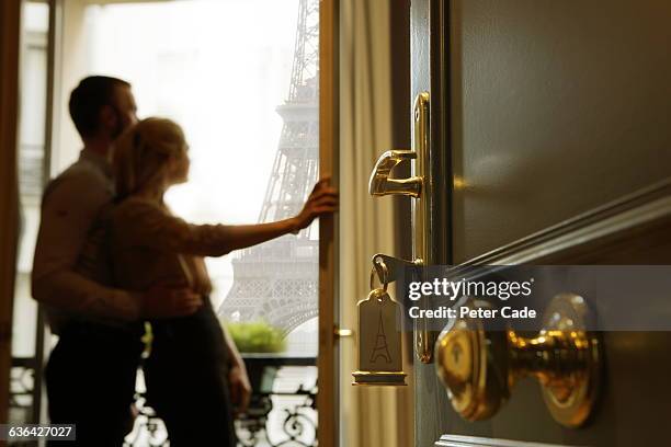 couple stood on hotel room balcony, eiffel tower - hotel tür stock-fotos und bilder