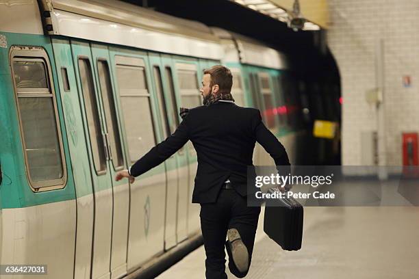 man running for underground train - run photos et images de collection