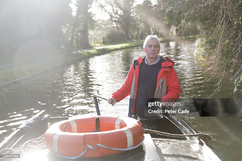 Man driving canal boat