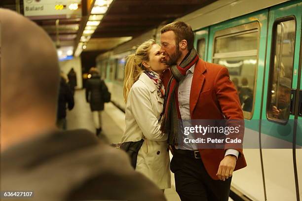 couple embracing on underground platform - metro platform stockfoto's en -beelden