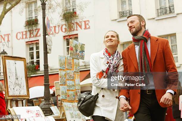 couple walking in paris street - montmartre stockfoto's en -beelden