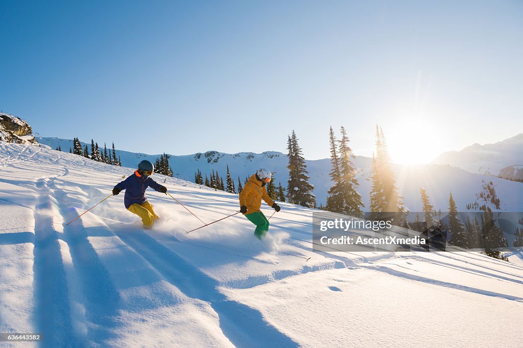 Couple skiing on a sunny powder day