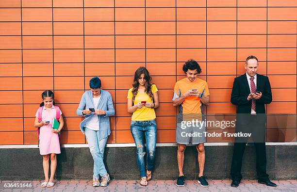 texting at different ages - person standing far stockfoto's en -beelden