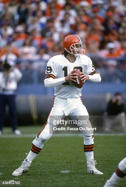 Bernie Kosar of the Cleveland Browns looks to throw a pass against the Denver Broncos during an NFL Football game circa 1990 at Mile High Stadium in...