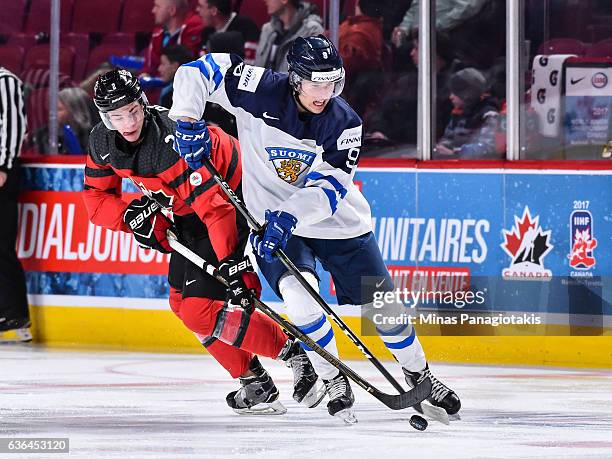 Janne Kuokkanen of Team Finland defends the puck against Jake Bean of Team Canada during the IIHF exhibition game at the Bell Centre on December 19,...