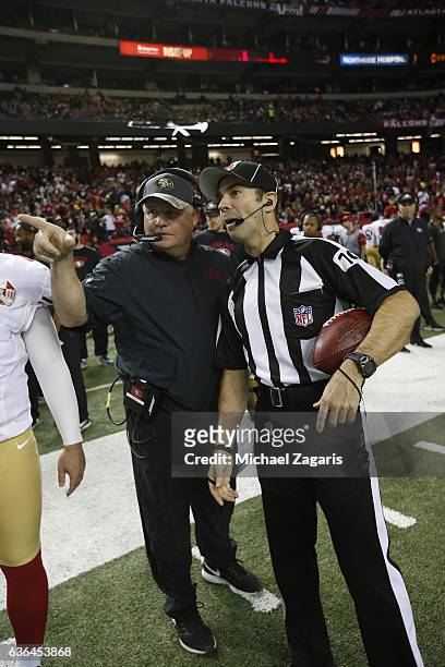 Head Coach Chip Kelly of the San Francisco 49ers talks with Official Gary Arthur on the field prior to the game against the Atlanta Falcons at the...