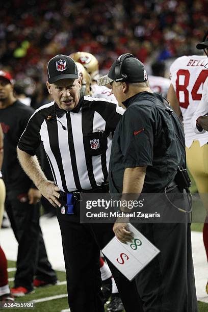 Official Gene Steratore talks with Head Coach Chip Kelly of the San Francisco 49ers on the field during the game between the 49ers and the Atlanta...