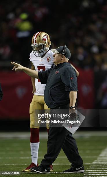 Colin Kaepernick and Head Coach Chip Kelly of the San Francisco 49ers talk on the field during the game against the Atlanta Falcons at the Georgia...