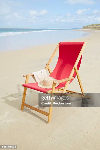 red deckchair on the beach in france - liegestuhl stock-fotos und bilder