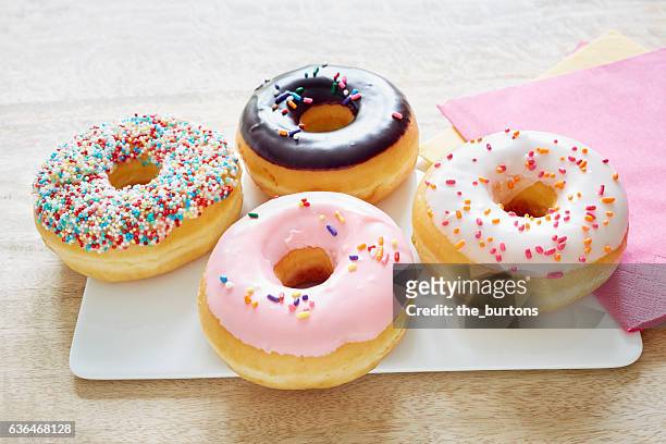 close-up of colorful donuts on table - donut stock pictures, royalty-free photos & images
