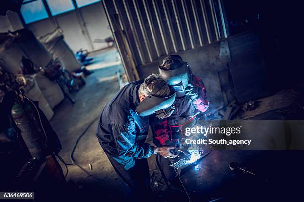 welder team in workshop - lasser stockfoto's en -beelden