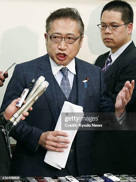 Japan - Your Party leader Yoshimi Watanabe answers reporters' questions at the Diet building in Tokyo on March 27 over an unaccounted-for 800 million...