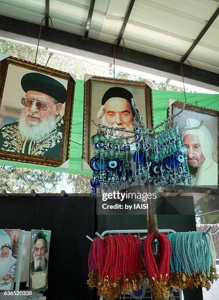 portraits of celebrated rabbis and apotropaic items at the tomb of moses maimonides, tiberias - kabbalah bracelet stock-fotos und bilder