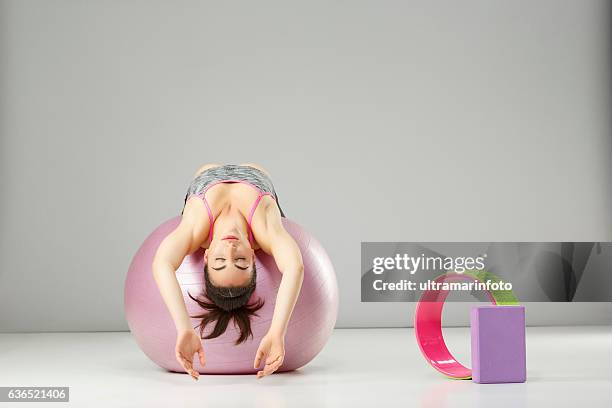 entrenamiento de estiramiento de pilates mujer practicando en una pelota de fitness - yoga ball fotografías e imágenes de stock