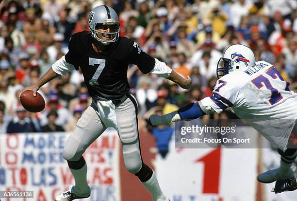 Quarterback Dan Pastorini of the Oakland Raiders scrambles away from the pressure of Ben Williams of the Buffalo Bills during an NFL football game...