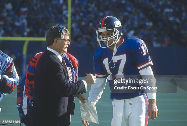 Quarterback Dave Brown of the New York Giants talks with his head coach Dan Reeves on the sidelines during an NFL football game circa 1995 at The...