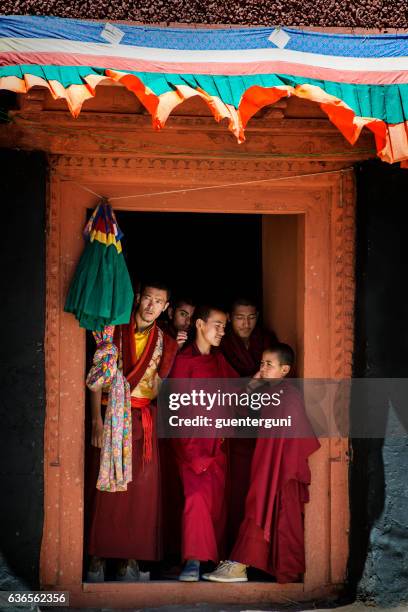 young buddhist monks standing in a door and watching festival - ladakh region stock pictures, royalty-free photos & images