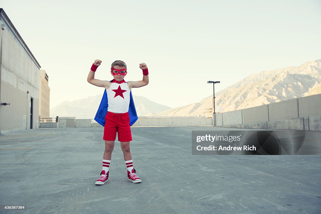 Young Boy Dressed as Superhero Flexes Muscles
