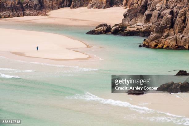the granite cliffs of porthcurno with sandy beaches mid tide. - porthcurno stock-fotos und bilder
