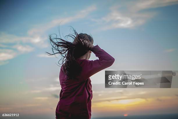 young woman with long hair blowing in the wind - brown hair blowing stock pictures, royalty-free photos & images