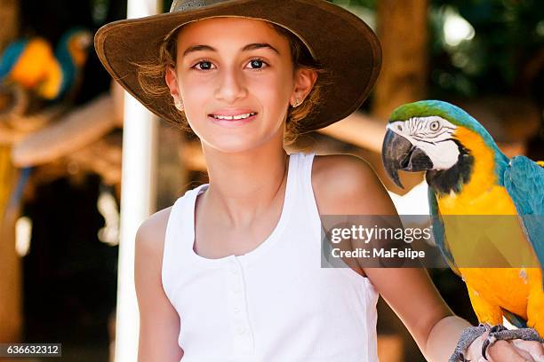 little girl holding a macaw in her arm - foz do iguacu stock pictures, royalty-free photos & images