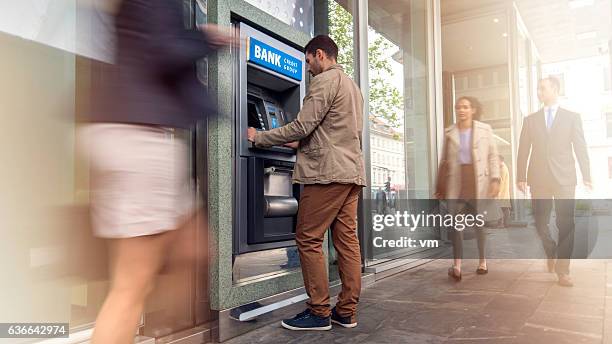 man in front of an atm machine - atm 個照片及圖片檔