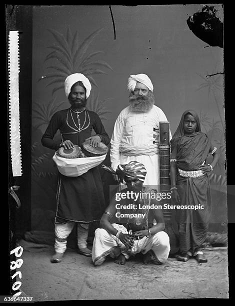 Group of indian musicians, 25th July 1877. The man on the left is presumed to be the well known conjurer and snake charmer, Moonshe Shaikh Gheesa.