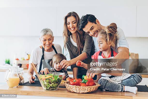 multi-generation family cooking - family at kitchen stockfoto's en -beelden