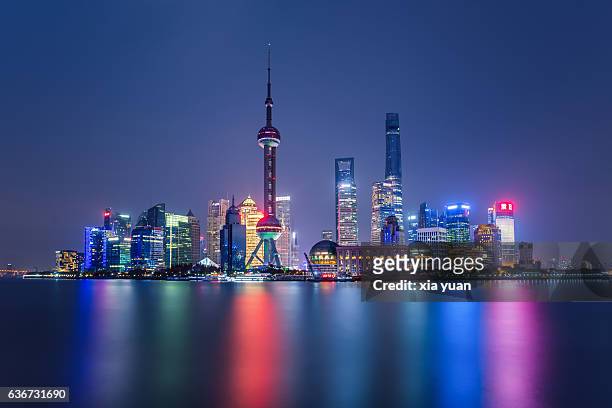 illuminated shanghai skyline reflecting on river - luogo d'interesse internazionale foto e immagini stock