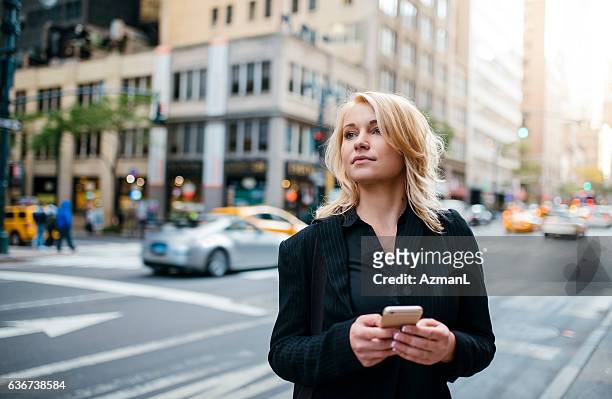waiting for taxi and texting - businesswoman nyc stockfoto's en -beelden