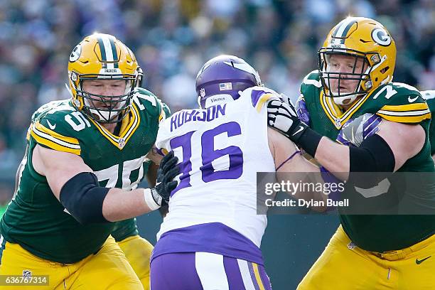 Bryan Bulaga and T.J. Lang of the Green Bay Packers block against Brian Robison of the Minnesota Vikings in the first quarter at Lambeau Field on...