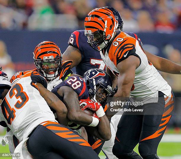 Alfred Blue of the Houston Texans is tackled by George Iloka of the Cincinnati Bengals and Michael Johnson at NRG Stadium on December 24, 2016 in...