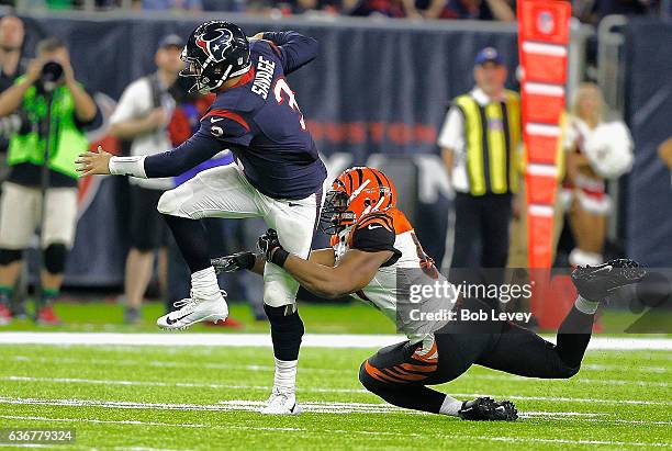 Tom Savage of the Houston Texans scrambles as Vincent Rey of the Cincinnati Bengals tackles at NRG Stadium on December 24, 2016 in Houston, Texas....