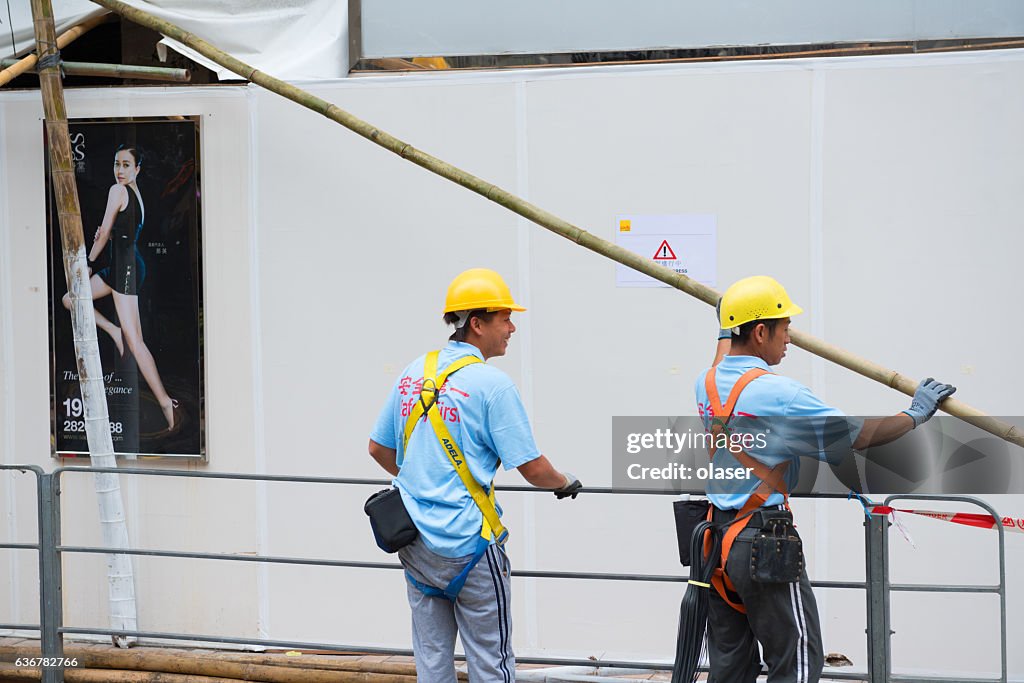 Zwei Bauarbeiter bauen Gerüste aus Bambus