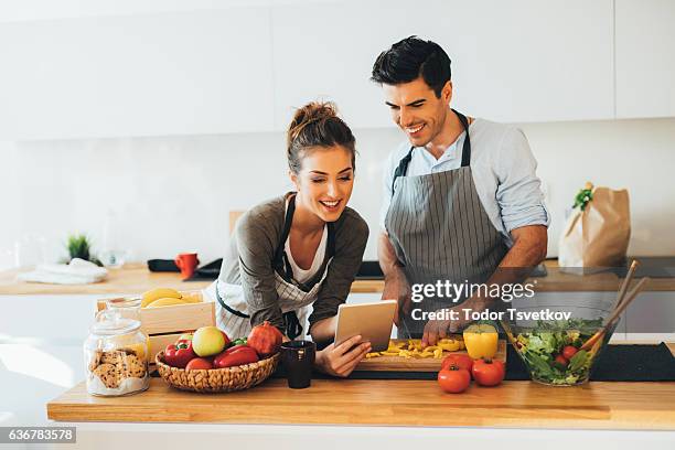 young couple cooking in the kitchen - diet journal stockfoto's en -beelden