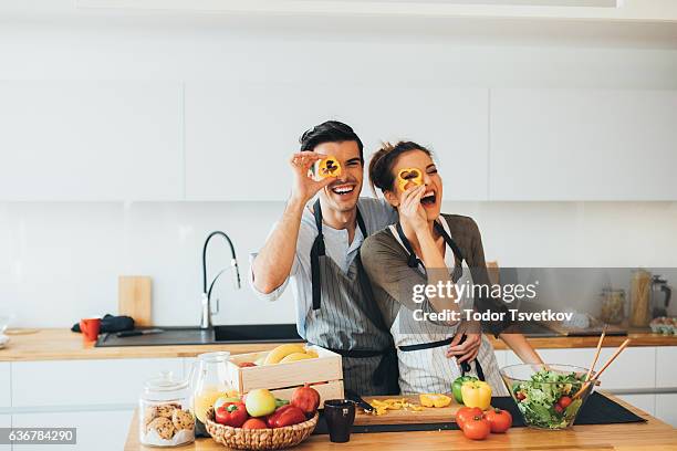 junges paar, die spaß in der küche - pepper vegetable stock-fotos und bilder