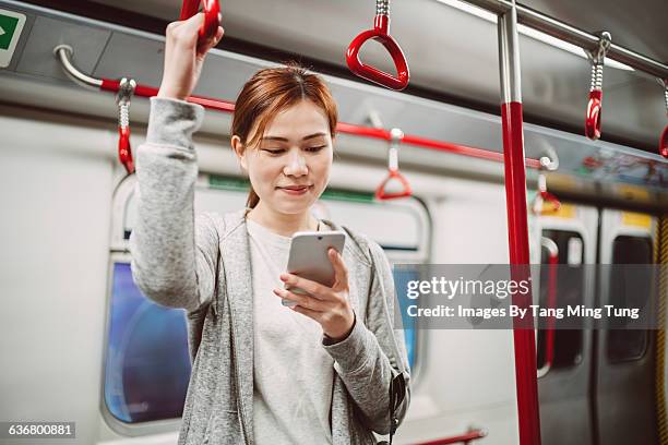 Pretty lady using smartphone in subway joyfully